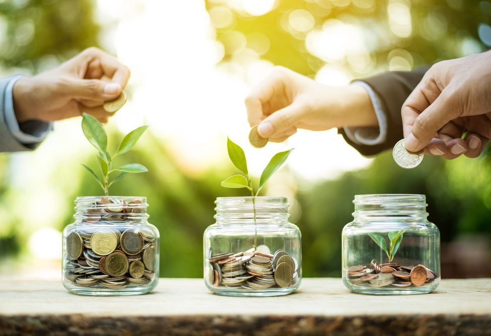 Businessman,Hands,Putting,Money,(coin),Into,The,Glass,Jar,-